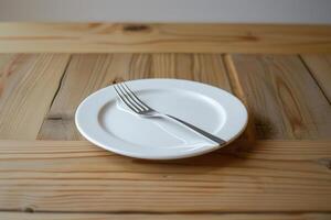 empty white plate and fork on wooden table photo