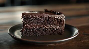 Decadent chocolate cake slice on dark plate photo