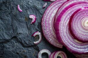 Sliced red onion on dark stone background photo