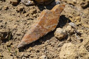 ancient stone tool artifact found in dirt photo