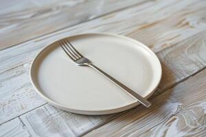 empty plate and fork on wooden table photo