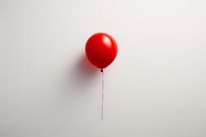 Vibrant red balloon floating against a plain background photo