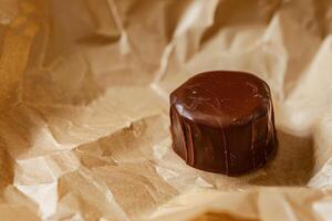 Delicious chocolate candy on crinkled paper photo