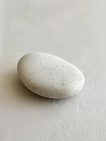 Smooth stone on a textured surface photo