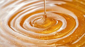 Honey dripping from a spoon into a swirling pool photo