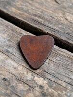 Rusty heart shaped object on weathered wood photo