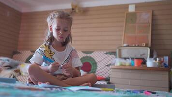 Cute girl talking while coloring in book on bed at home video