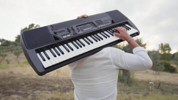 Man Walks Playing Musical Keyboard On Shoulder In Nature video