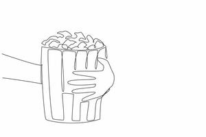 National Popcorn Day. One single line drawing of hand grabbing stripped pop corn paper bucket contain sweet popcorn. Delicious snack to accompany watching movie. Continuous line draw graphic vector