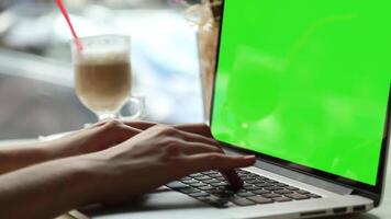 A man typing on a laptop with a green screen in an office ideal for app design digital content creation and professional mockup presentations video
