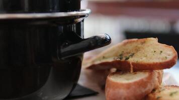 saucepan with mussels with cream sauce and tasty bread with garlic and spices on table of restaurant video