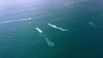 Aerial view of a motor boat forming a circle of waves and bubbles with its engines over the turquoise sea. Drone flight, summer vacation concept, banner. video