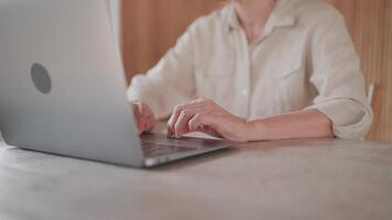 Hands of Senior woman typing on laptop at desk, thinking or expressing concern, looking at device screen, studying received email, contemplating work, working online, prepare report. video