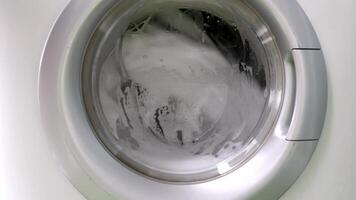 de cerca de ropa Lavado en un máquina con espuma. concepto de lavadero, limpieza, y moderno casa quehaceres en diario vida. video