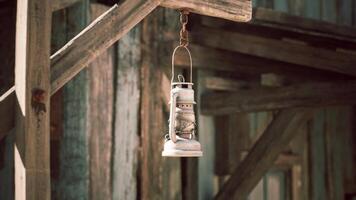 Rustic lantern hanging from a wooden beam in a vintage farm setting video