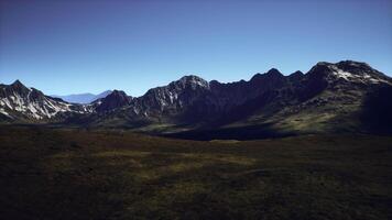 Dramatic mountain range under a clear blue sky during daylight hours video