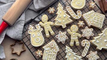 Christmas cookies cooling on a rack, with a rolling pin and cookie cutters in the background video