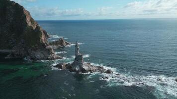 Top view of rocks in sea with abandoned lighthouse. Clip. Beautiful view of old lighthouse and rocky cape in sea. Landscape lighthouse on rocky cape in ocean on sunny summer day video