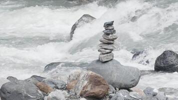 Harmony, balance and simplicity concept. A stone pyramid on the background of river water. video