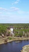 un asombroso aéreo ver exhibiendo el sereno bosque a lo largo con un encantador río paisaje. valores acortar video