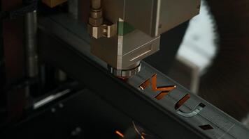 Laser cut head machine while cutting the sheet metal with the sparking light in factory. Creative. Process of laser engraving on metal. video