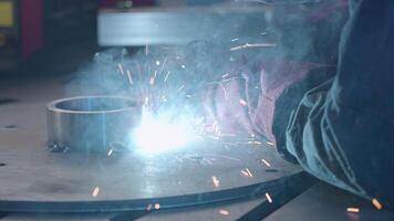 Welder in gloves holds welding with flying sparks. Creative. Sparks while working with welding and steel structures. Welding tube with sparks from metal structure video