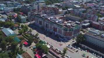 Top view of buildings in city on sunny summer day. Clip. Moving cars in city center on summer day. Simple city with multi-storey buildings in summer video