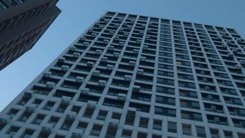 Low angle view of a multi storey building on blue sky background. Media. Newly built residential houses. video
