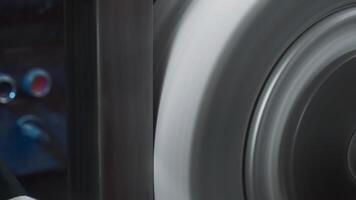 Close-up polishing of steel part on rotating machine. Creative. Rectangular steel part is polished on rotating machine. Worker in gloves polishes part on machine video