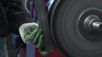 Close-up of worker polishing steel part on machine. Creative. Worker in gloves polishes part on rotating machine. Rotating factory drain but for polishing metal parts video