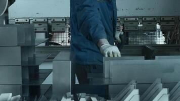 Worker manually assembles machine with metal parts. Creative. Work at factory for collection of metal structures and machine tools. Worker collects lot of metal parts at factory video
