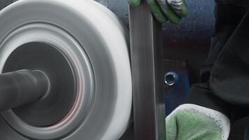 Close-up of worker polishing steel part on machine. Creative. Worker in gloves polishes part on rotating machine. Rotating factory drain but for polishing metal parts video