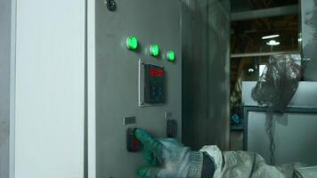 Worker in work uniform presses control panel of factory machines. Creative. Worker in mask and uniform at nuclear plant. Worker in equipment and mask presses industrial production control buttons video