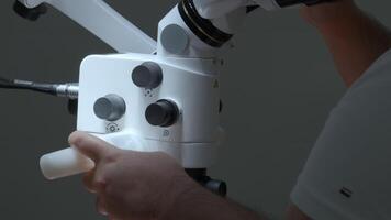 Male doctor using microscope in laboratory. Action. Man in lab examines sample during work in clinic in daytime. video