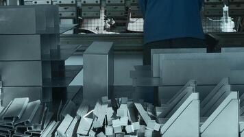 Worker manually assembles machine with metal parts. Creative. Work at factory for collection of metal structures and machine tools. Worker collects lot of metal parts at factory video