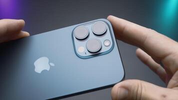 China, Beijing - September 15, 2023. Design of new iPhone 15 pro. Action. Stylish model of new iPhone 15 pro in lucky man's hands. Luxury design of new iPhone 15 pro on isolated background video