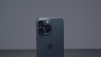 China, Beijing - September 15, 2023. New iPhone 15 pro. Action. New iPhone model from Apple with stylish design and additional technologies. Stylish iPhone model 15 pro max on gray background video