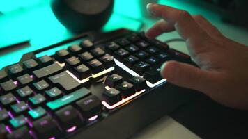Young gamer plays a game or typing on colorful keyboard, close up. Clip. Player uses gaming illuminated keyboard, concept of cybersport. video