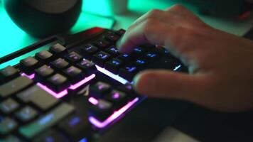 Young gamer plays a game or typing on colorful keyboard, close up. Clip. Player uses gaming illuminated keyboard, concept of cybersport. video