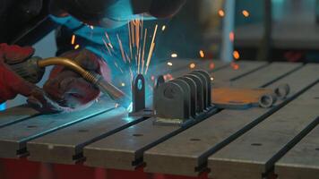 Close up of blacksmith welder in protective uniform works with metal steel and iron using a welding machine. Creative. Bright sparks and flashes, heavy industry concept. video