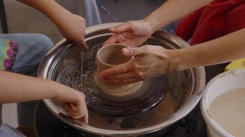 Creating pottery on the wheel in a studio with children in the afternoon video