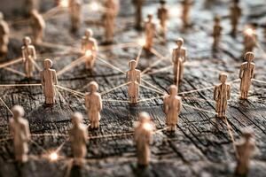 A conceptual image showcasing interconnected wooden figures symbolizing human connections, collaboration, and a network, illuminated with light points, emphasizing the significance photo
