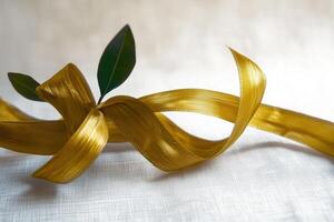 A golden ribbon intertwined with green leaves symbolizes elegance and nature photo