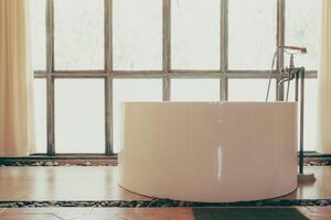 A bathtub in a bathroom with a window photo