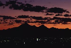 Dramatic Dusk. A Vibrant Red Sky Over Serene Mountain Waters photo