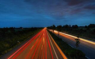 Tranquil Roadway Beneath a Cloudy Sky with Lush Greenery photo