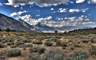 Majestic Highland View with Cumulus Clouds Over Mountain Range and Grasslands photo