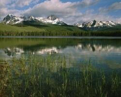 Breathtaking Highland Lake Surrounded by Majestic Mountains and Dramatic Clouds photo