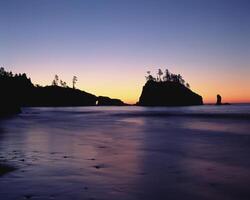Tranquil Sunset Over Coastal Landforms with Afterglow Reflections on Water photo