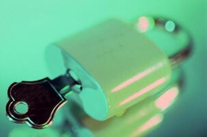 Macro Shot of Padlock with Key on Green Background photo